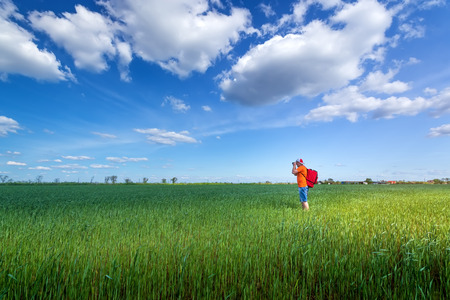 photographer in search of a story / bright summer day unrealistically beautiful skyの写真素材