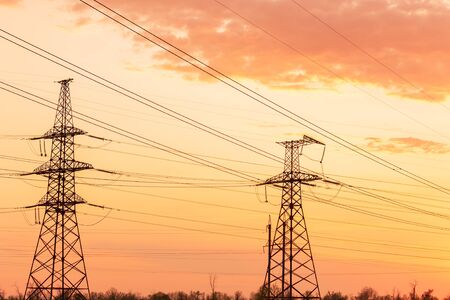 power line on the field / sunset time industrial power polesの写真素材