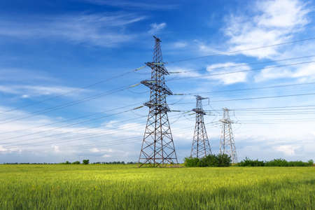 power line summer landscape / passing overhead electricity wire of the support carrying the light and the heat in the houseの写真素材