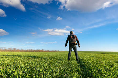 sunset on the field, a man standing on the field meets the sunsetの写真素材