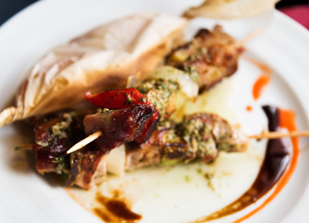 Grilled meat skewers with vegetables. Shallow field of depth, focus on the end of top skewerの写真素材