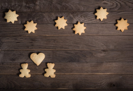 Two cookies bears with heart on left side, stars on top, rustic wooden background