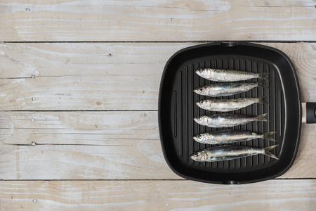 Grill pan with sardines on wooden backgroundの写真素材