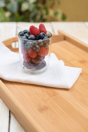 Berries in glass white napkin rustic wooden tableの写真素材