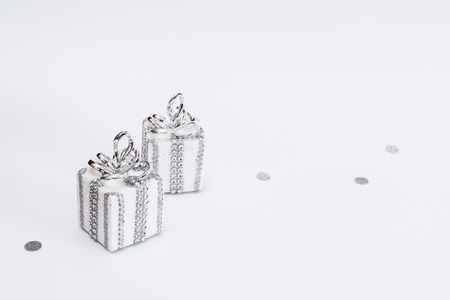 Two white and silver gifts on white background with decorative glitterの写真素材