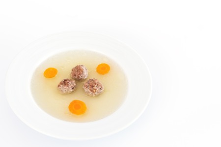 Plate of soup with carrot and meat balls on white backgroundの写真素材