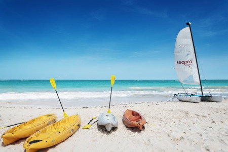 PUNTA CANA, DOMINICAN REPUBLIC - OCTOBER 2015: canoe and sail boat waits for clients on the beachのeditorial素材