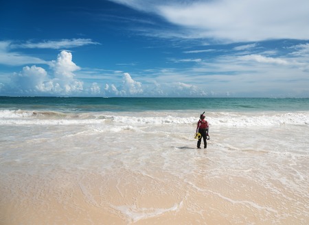 Punta Cana, Dominican Republic - October 9th 2015: Unknown man in costume for diving holds metal detector and prepare to dive. A lot of people search for lost bijouterie on beaches as a hobby or main jobのeditorial素材
