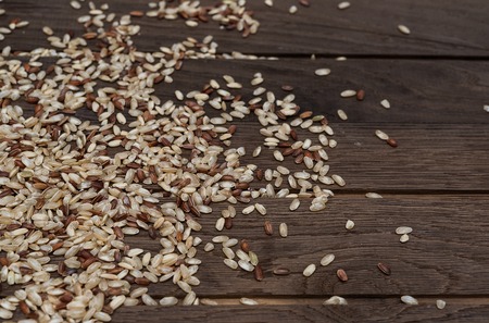 Raw brown wholegrain rice on wooden backgroungの写真素材