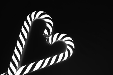Heart from candy canes with glowing effect, black and white toning, inverted colorsの写真素材