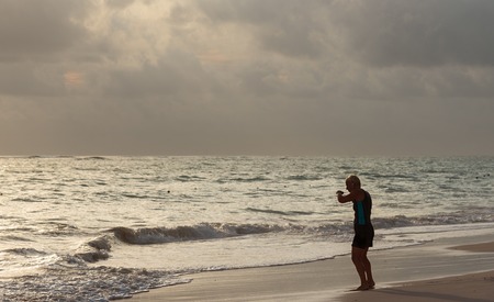 Punta Cana, Dominican Republic - October 2th 2015: mature unknown woman does fitness training on the beach during sunriseのeditorial素材