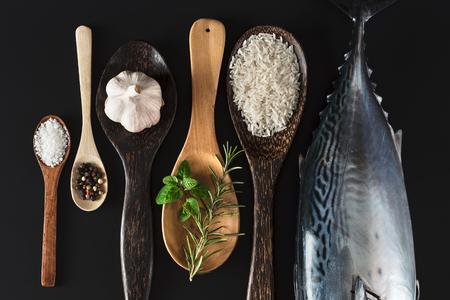 Fresh fish, rice and spices on black backgroundの写真素材