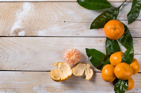 Fresh mandarines with leaves on wooden tableの写真素材