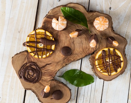 Top view on citruses with chocolate on wooden boardの写真素材