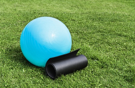 Fitness ball and mat on grass, natural daylightの写真素材