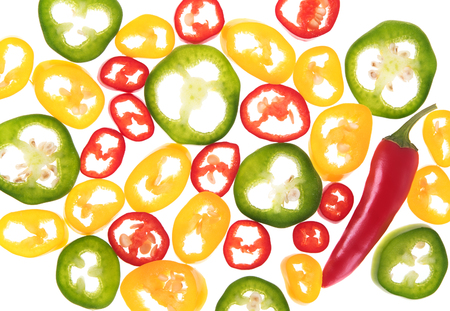 Sliced chili peppers and one whole pepper on white backgroundの写真素材