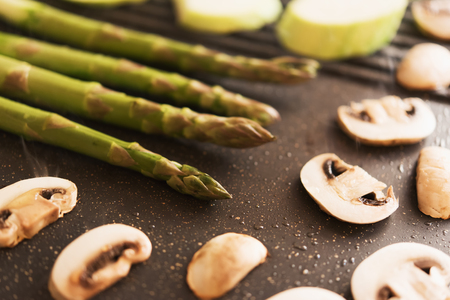 Asparagus, mushrooms and zucchini on electrical grillの写真素材