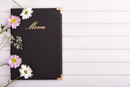 Top view on menu decorated with white and pink flowersの写真素材