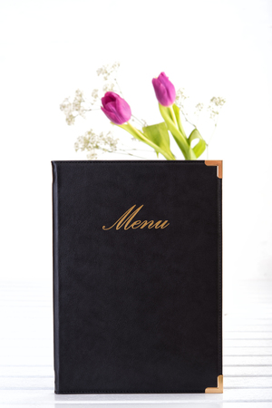 Menu and vase with flowers on white wooden tableの写真素材