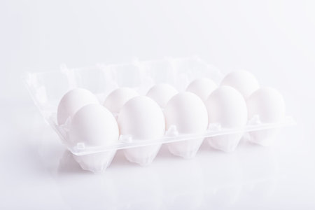 Box with white eggs on white backgroundの写真素材