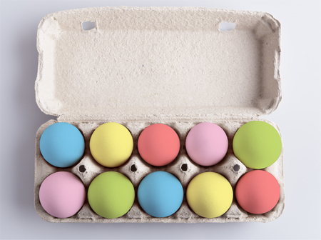 Box with painted multicolor eggs on white backgroundの写真素材