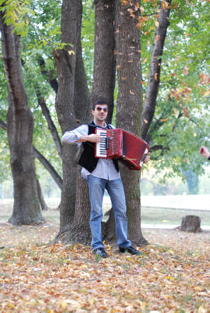 Man playing accordion in parkの写真素材