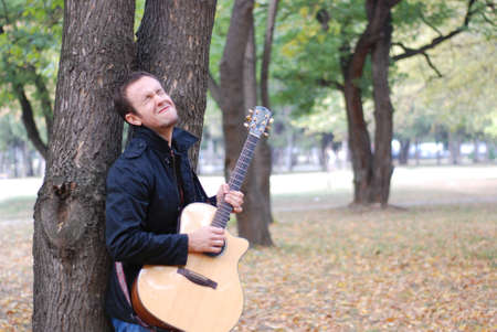 Man playing guitar in parkの写真素材