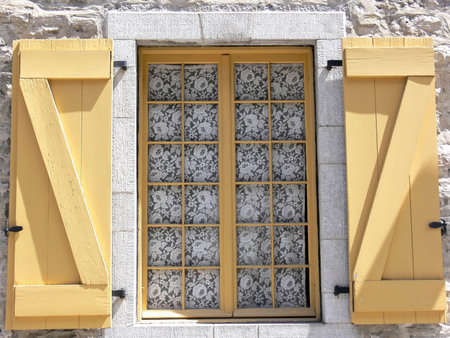 Traditional lace window covering on a window in Quebec City.
