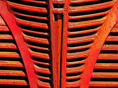 Grillwork on the front of a red vintage truck の写真素材