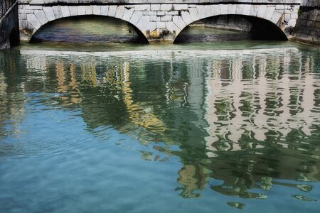 The bridge at Annecy, France reflecting in the river Thiou.の写真素材
