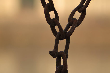 old iron chains hanging on an orange backgroundの写真素材