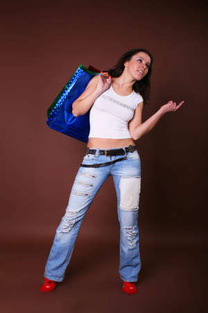 The young beautiful girl with purchases in color packages during shopping on a color backgroundの写真素材