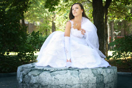 The young beautiful bride in white dress posing on a backgroundの写真素材