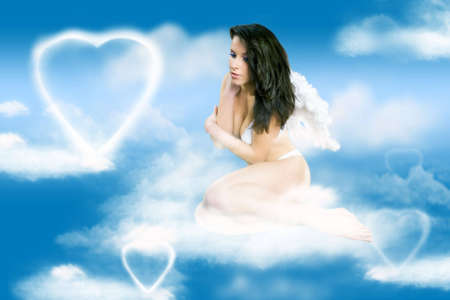 The young beautiful girl-angel on a clouds in the blue skyの写真素材