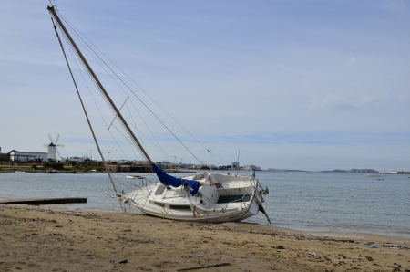 SAN ANTONIO-IBIZA-SPAIN-JANUARY-29/2013: boat swept by the storm of the previous day and stranded on the beach.のeditorial素材