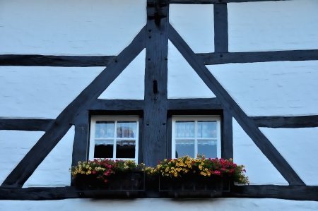 White windows of an old building with wooden beams on the faの写真素材