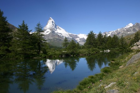 mount Matterhorn reflects in a wooded mountain lakeの写真素材