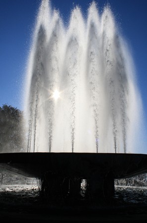 fountain gleams in the sun as the sun shines through the jetsの写真素材