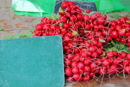 fresh red radish on a market stall presented with a slate with room for your textの写真素材