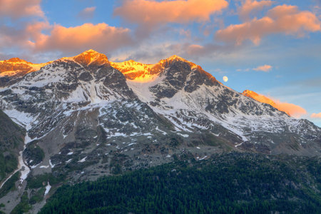 view from St. Moritz in Switzerland: high snow and ice capped alpine mountain range with red...