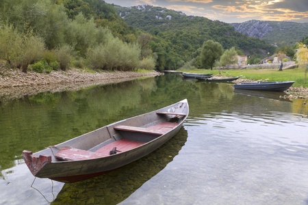 boats on a quiet, calm, clear mountain river running in green nature.の写真素材