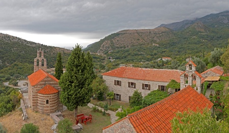 group of red roofed buildings forming a little church yard in the mountains of Montegroの写真素材