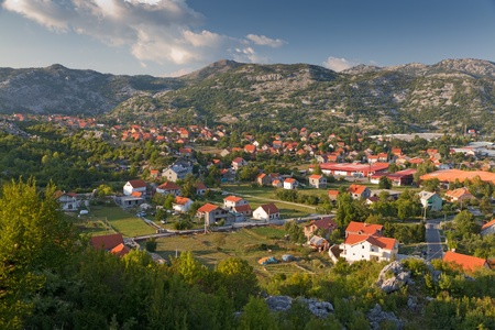 typical town with red roofed houses in green valley in warm later afternoon light, Montenegroの写真素材