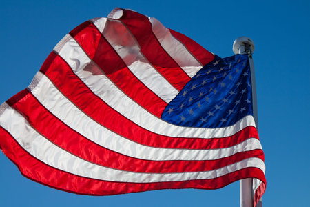 flying American backlight flag with copyspace against a blue sky