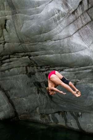 Foto de LOCARNO - JULY 23: Cliff diving athlete Anatolii Shabotencko competes in the WHDF European Championship 2011 with dives from up to 20m high at Ponte Brolla July 23, 2011 in Locarno, Switzerland.  - Imagen libre de derechos