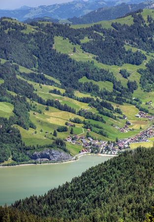 swiss alpine mountain scenery with lake and little town near town Schwyz, Switzerlandの写真素材