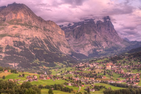Famous alpine town Grindelwald in valley at sunset in front of mountain Eiger north face, Switzerlandの写真素材