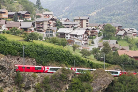 Glacier express train passes village, Switzerlandのeditorial素材