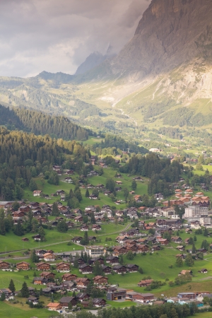 Famous alpine town Grindelwald in valley at sunset in front of mountain Eiger north face, Switzerlandの写真素材
