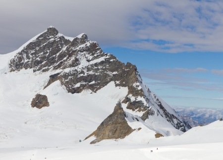 snow and ice crusted  top of 4,158 m high mountain Jungfrau, Bernese alps Switzerland with mountain station Sphinx, seen from Jungfraujochの写真素材
